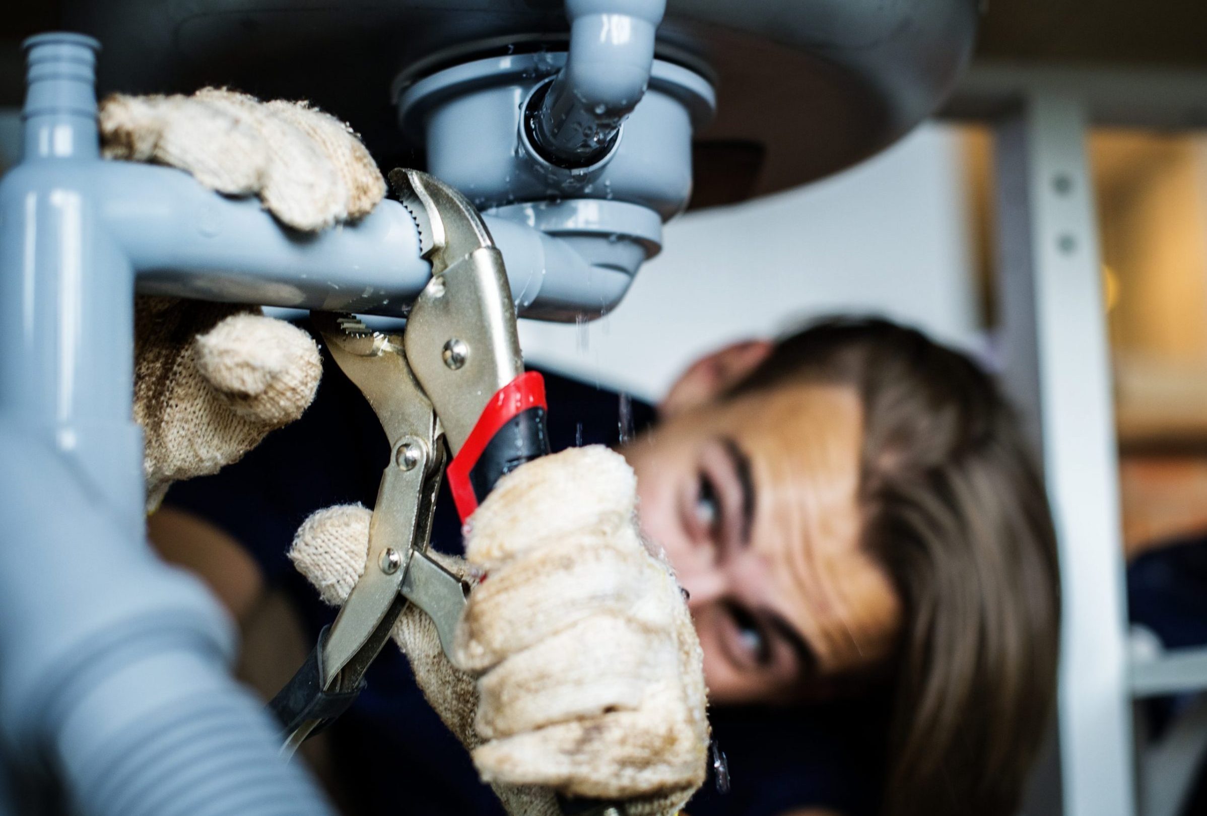 man fixing kitchen sink scaled e1738804831364